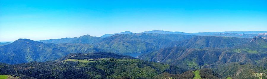 Panoramic view of mountains against clear blue sky