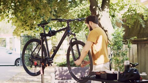 Side view of man riding bicycle on street