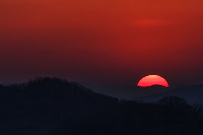 Scenic view of silhouette mountains against sky at sunset