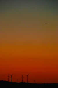 Silhouette of wind turbines at sunset