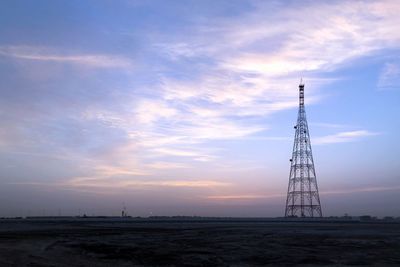 Low angle view of communications tower against sky during sunrise