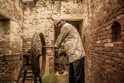 Portrait of mature man using machinery at home