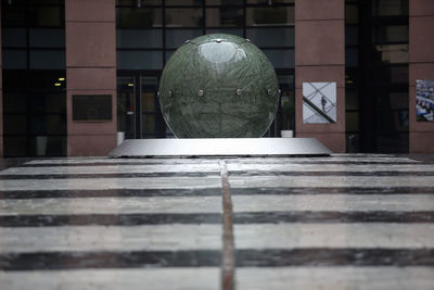 Close-up of glass ball on table against building in city