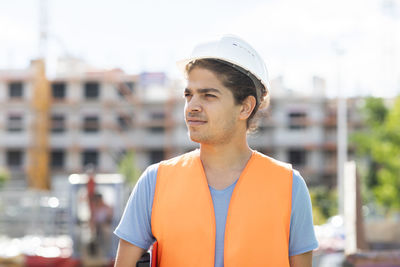 Young construction engineer with helmet working outside