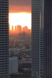 Buildings in city against sky during sunset