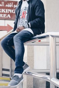 Low section of man sitting on book