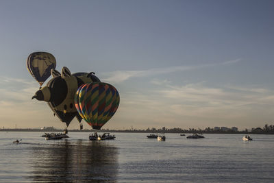 Hot air balloon over sea against sky