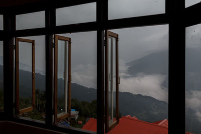 Scenic view of mountains against sky seen through window