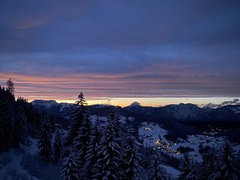 Aerial view of snow covered landscape against sky during sunset