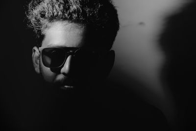 Close-up of man wearing sunglasses in darkroom