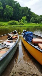 Boats moored on river against trees in forest