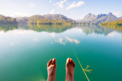 Low section of man on lake against sky