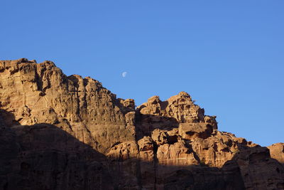 Low angle view of rock formations against clear blue sky