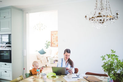 Female freelancer working while taking daughter's care at home office