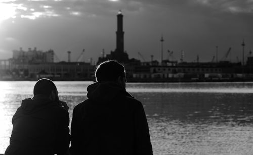 Rear view of two men in city against sky