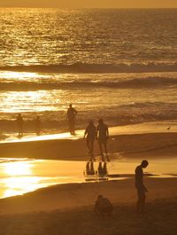 High angle view of silhouette people at beach during sunset