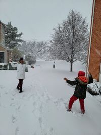 Rear view of woman walking on snow covered landscape