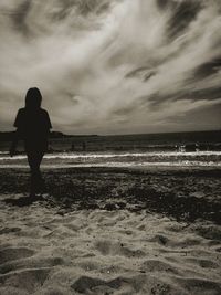 Rear view of silhouette woman standing on beach