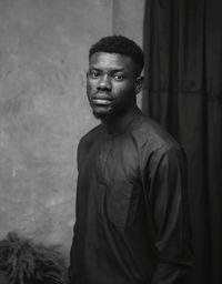 Young man standing against wall