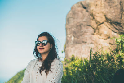 Young woman wearing sunglasses against clear sky