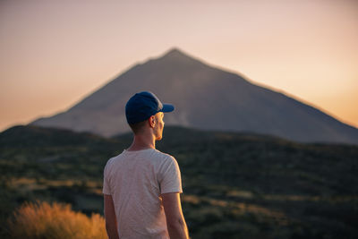 Side view of man standing against mountain