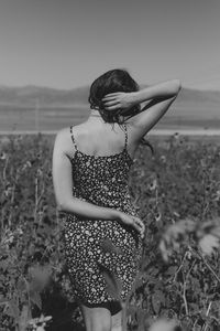 Rear view of woman standing on field