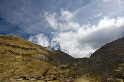 Scenic view of mountains against cloudy sky