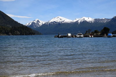 Scenic view of sea and snowcapped mountains against sky