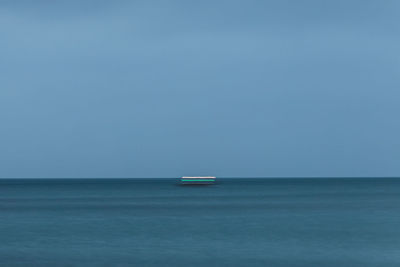 Scenic view of lights in the sea against clear sky