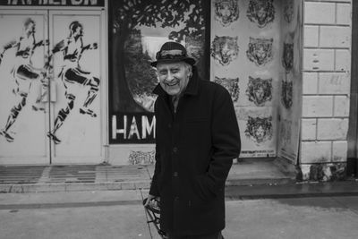 Portrait of man standing against wall