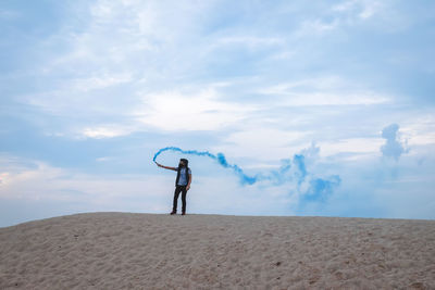 Man standing on sand against sky