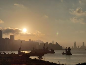 Scenic view of sea and buildings against sky during sunset