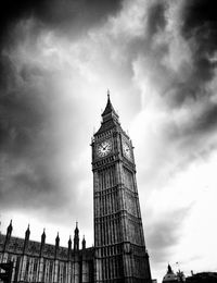 Low angle view of clock tower against cloudy sky