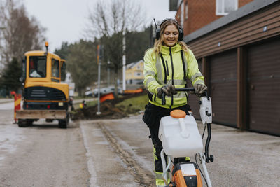 Female road worker operating machinery