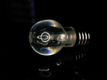 Close-up of light bulb against black background