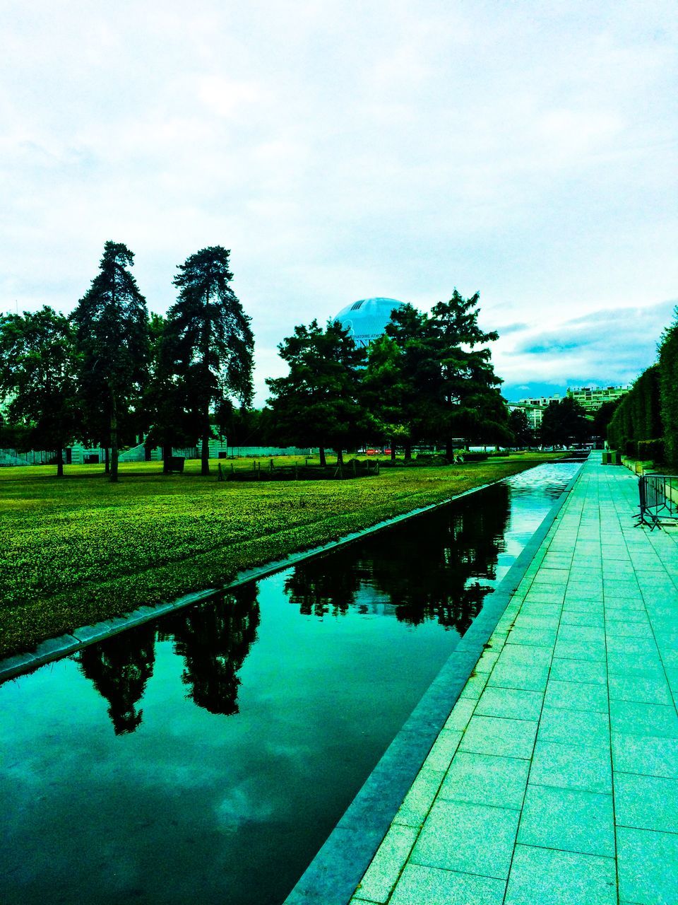 water, reflection, tree, sky, tranquility, pond, tranquil scene, green color, nature, blue, lake, cloud - sky, beauty in nature, canal, day, scenics, park - man made space, growth, outdoors, waterfront