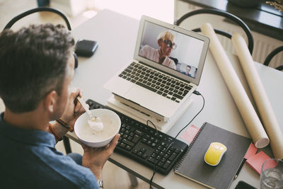 Businessman and businesswoman attending a video conference meeting working at home