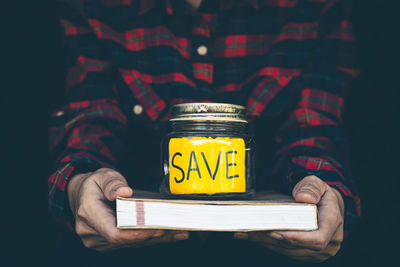 Midsection of man holding yellow while standing by text