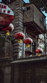 Low angle view of lanterns hanging by building in city