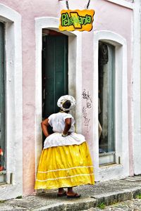 Rear view of woman with text on door of building