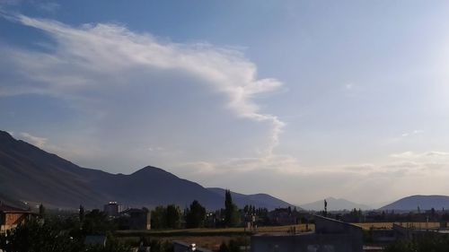 Town by mountains against sky