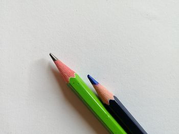 Close-up of colored pencils on table against white background