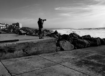 Man standing on shore against sky