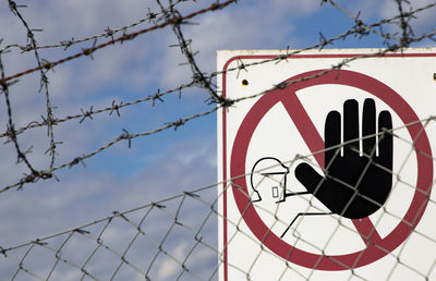 Close-up of warning sign on fence