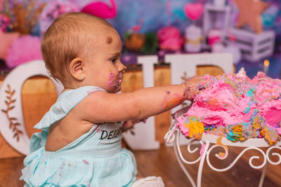 Messy baby eating birthday cake