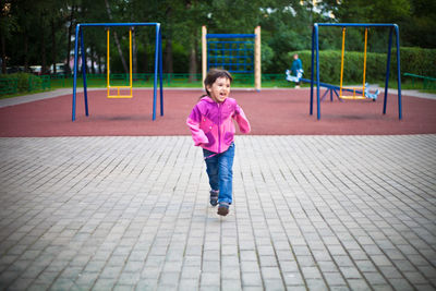 Cute girl running on footpath at playground