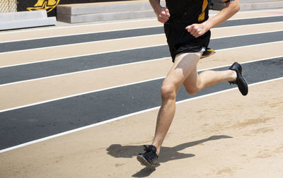 High school runner with wet shoes after exiting the steeplechase during a race on a track.