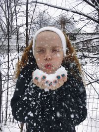 Close-up portrait of a girl standing in snow