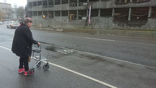 Rear view of woman riding motorcycle on road in city