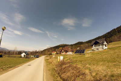 Narrow road to the mountains with houses and solar energy panel photovoltaic panels pv. electricity 